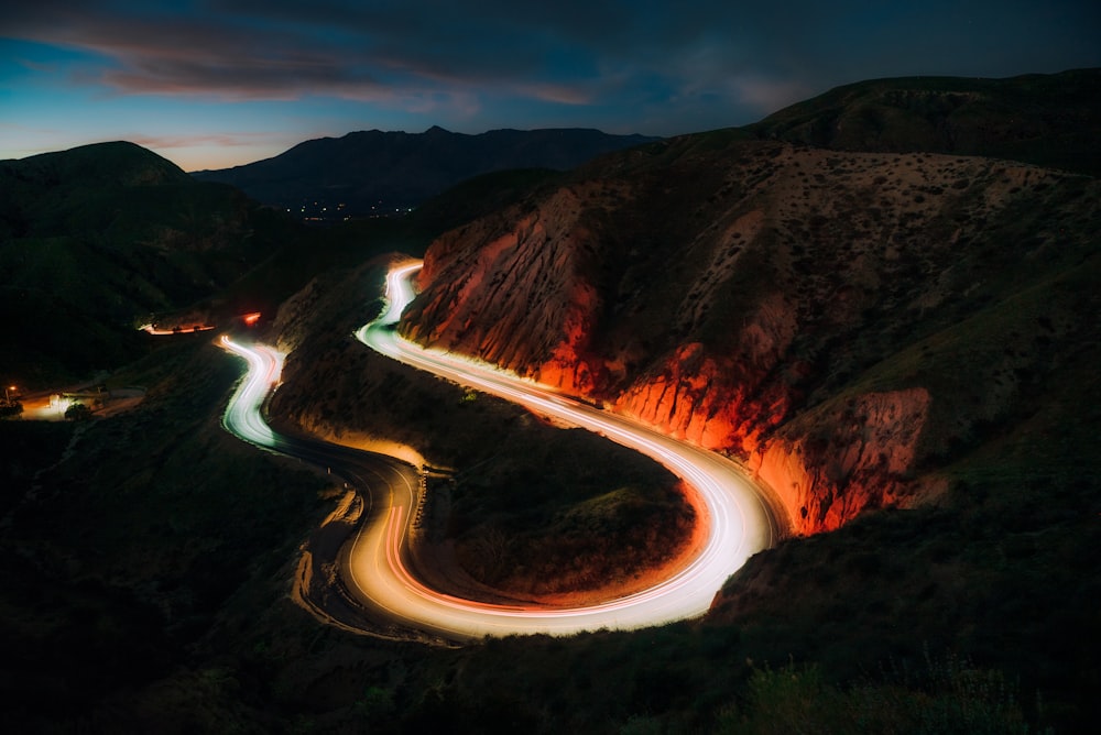 time lapse photography of river between brown mountains during night time