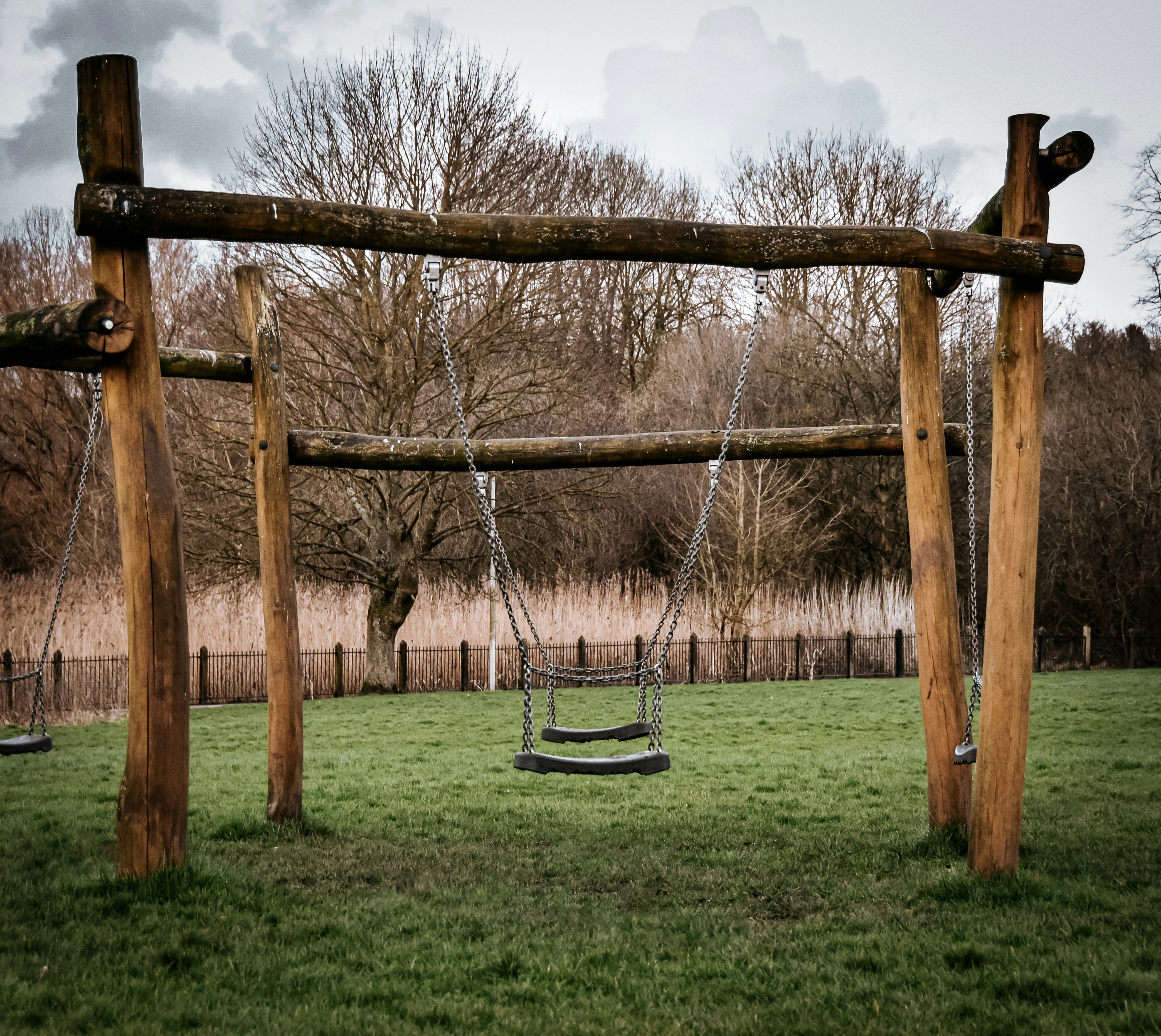 brown wooden swing on green grass field