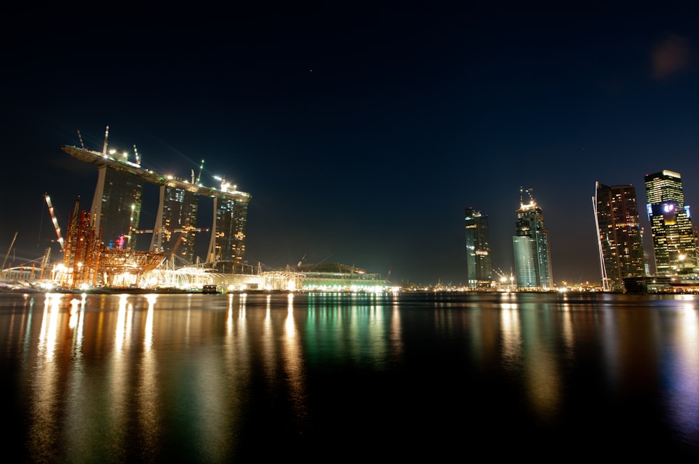 body of water near city buildings during night time