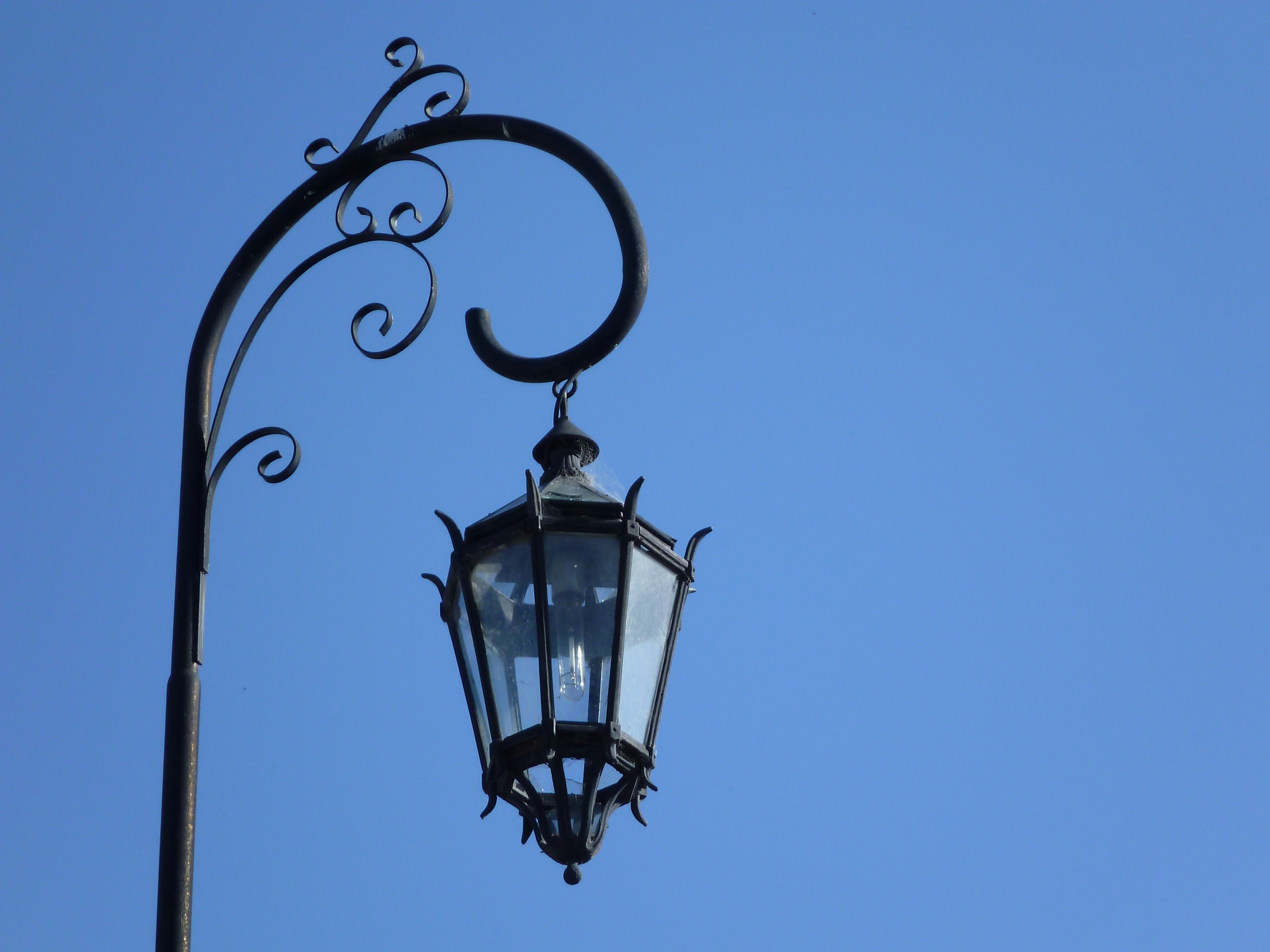 black street lamp under blue sky during daytime