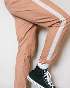 person in brown pants and black and white nike sneakers