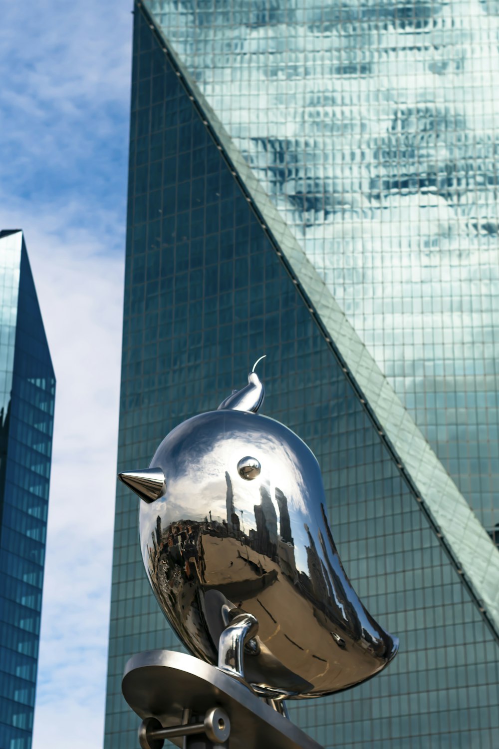 silver globe statue near glass building during daytime