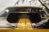 Close-up of a car's polished hood reflecting the sky.
