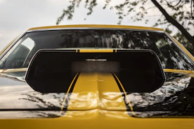 A close-up of a car's polished hood reflecting the sky