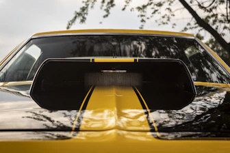 A close-up of a car's polished hood reflecting the sky