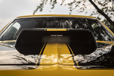 Close-up of a car's polished hood reflecting the sky.