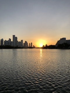 city skyline during sunset with body of water