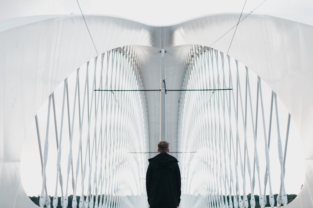 man in black suit standing on bridge