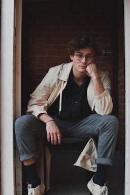 photography poses for men,how to photograph man in brown jacket and blue denim jeans sitting on brown wooden chair