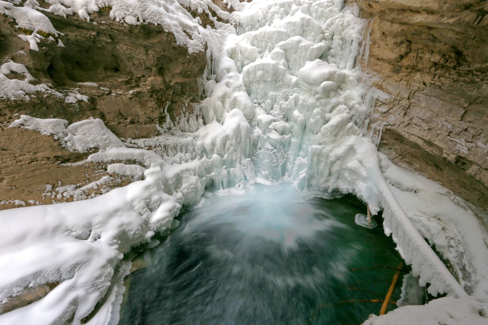 water falls on rocky mountain during daytime