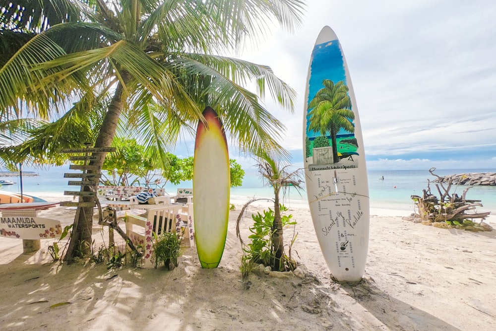 white and blue surfboard on beach during daytime