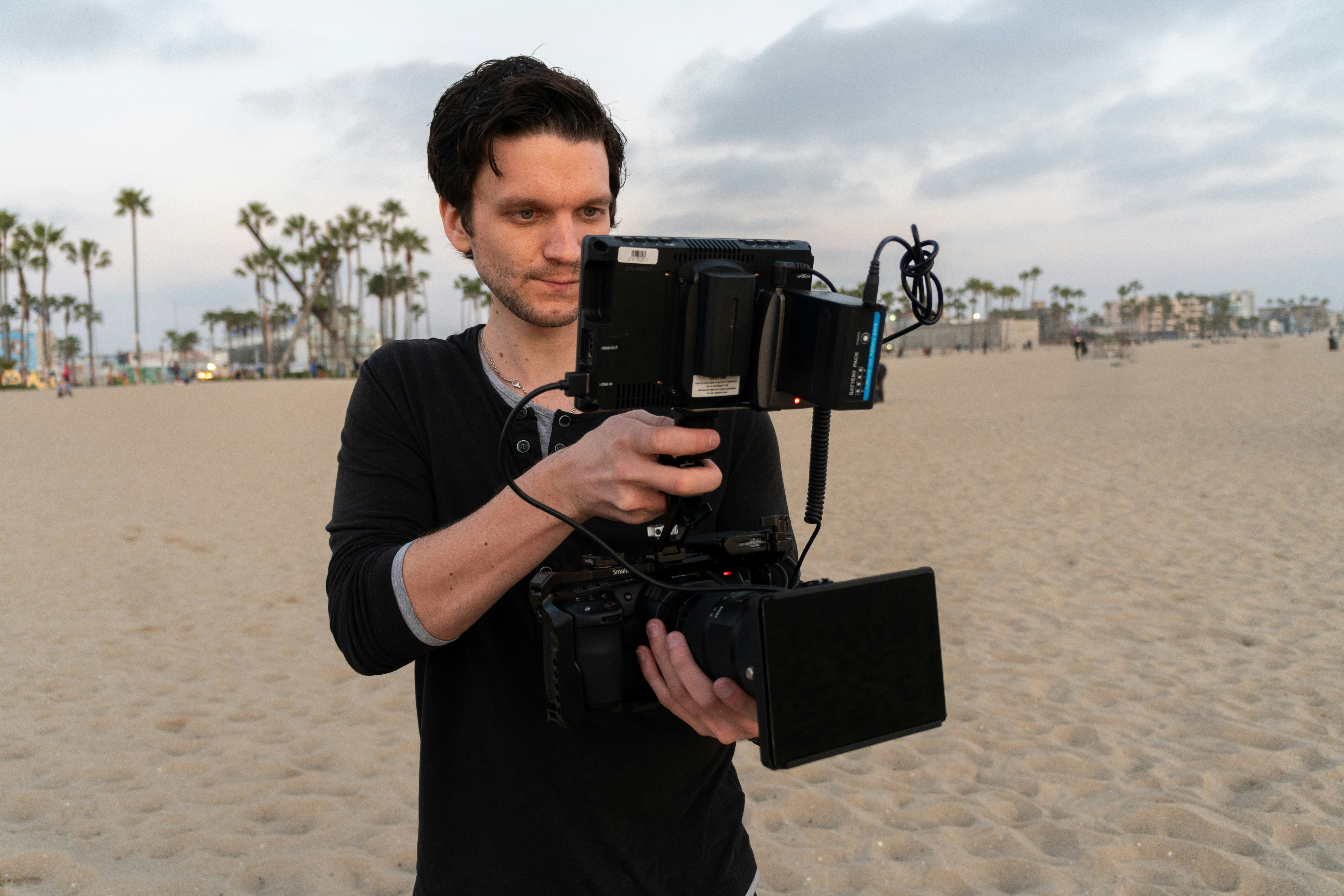 man in black t-shirt holding black dslr camera