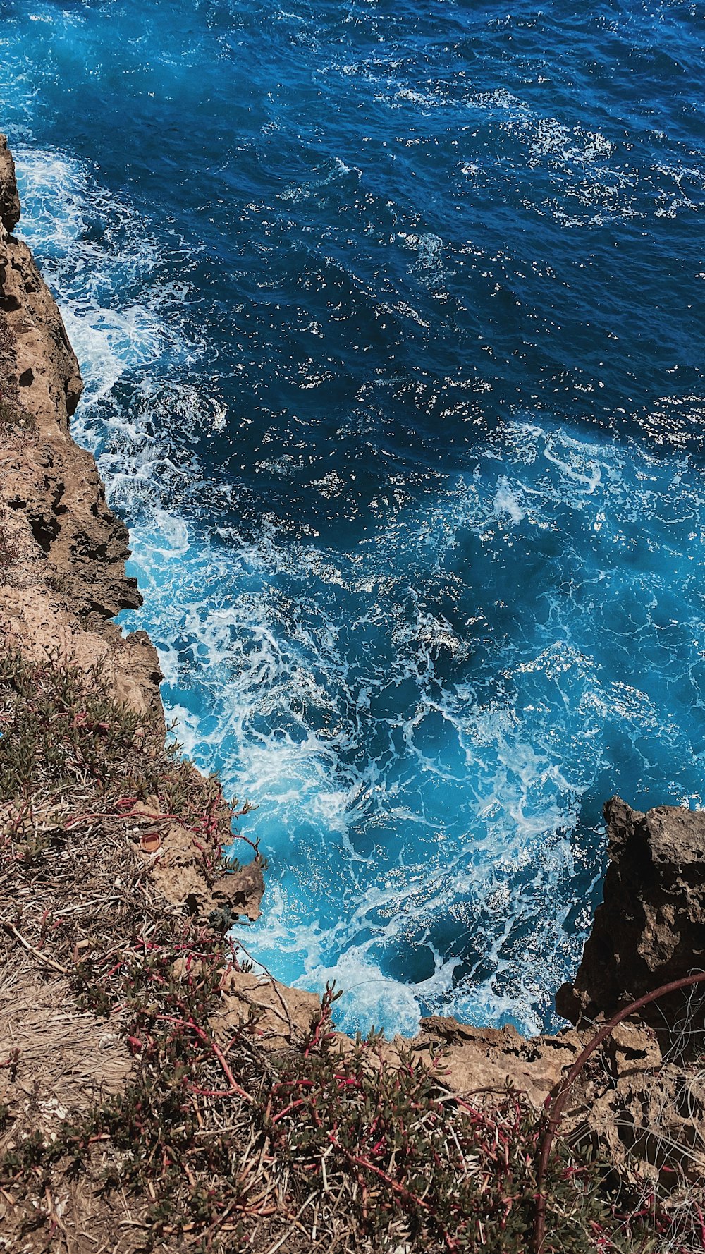 blue sea waves on brown rocky shore during daytime