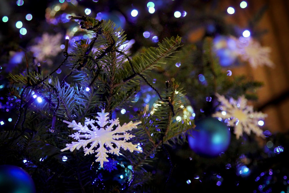 Weiße und blaue Weihnachtskugeln am grünen Weihnachtsbaum