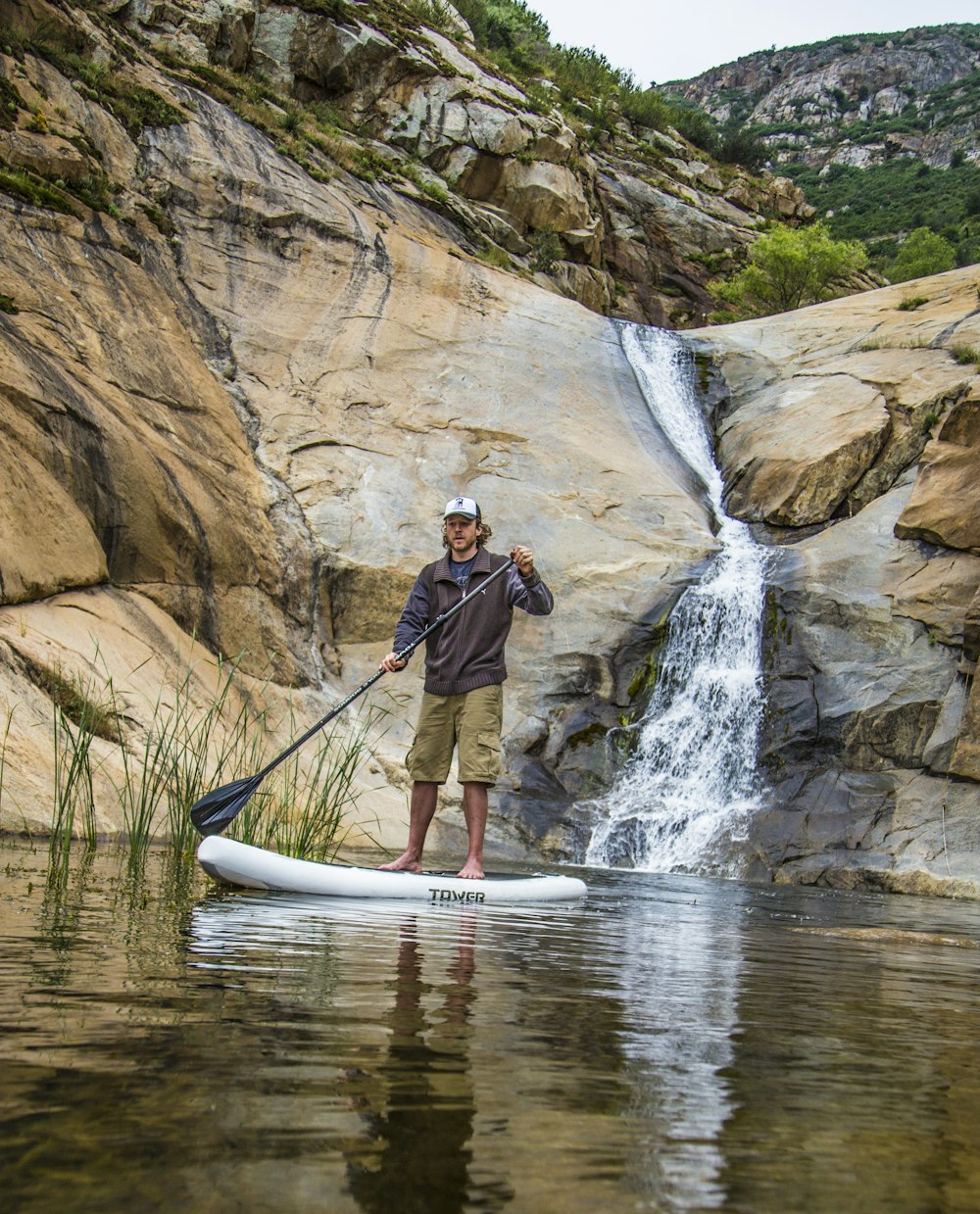 man in black jacket and black pants riding white kayak on river during daytime