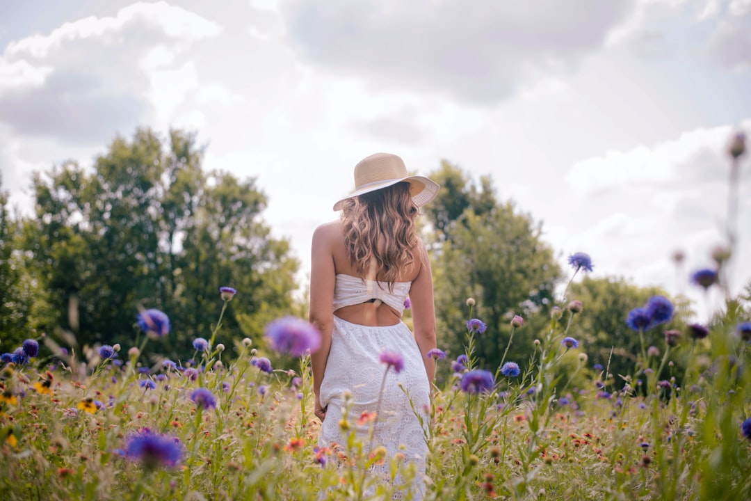 woman in white dress standing on green grass field during daytime