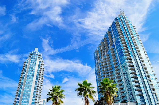 Palm trees in front of tall residential buildings under a clear blue sky, a familiar view in the Las Vegas valley