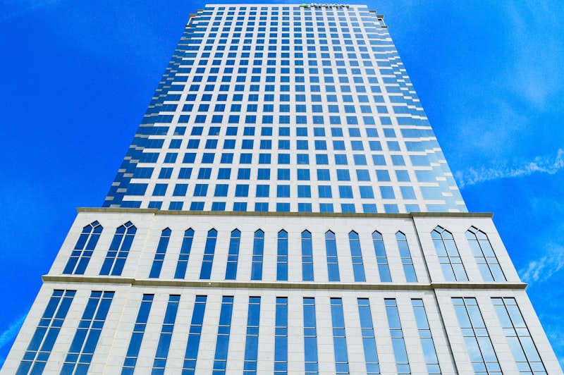 White and blue high-rise corporate building against a clear sky