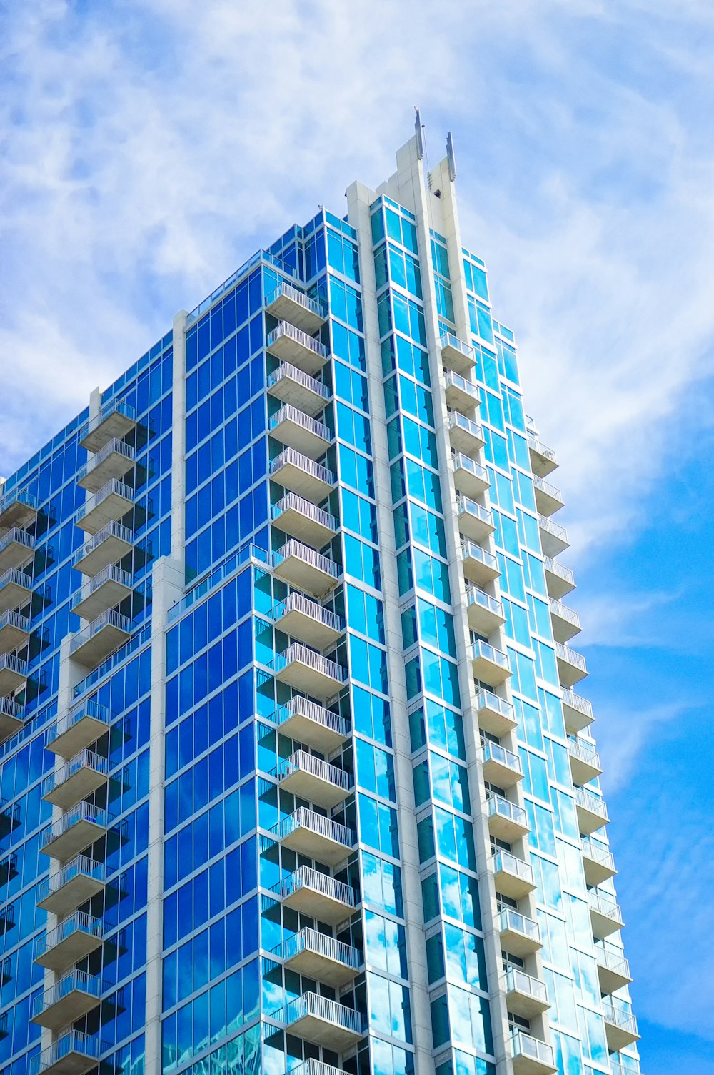 edifício de concreto branco e azul sob o céu azul durante o dia