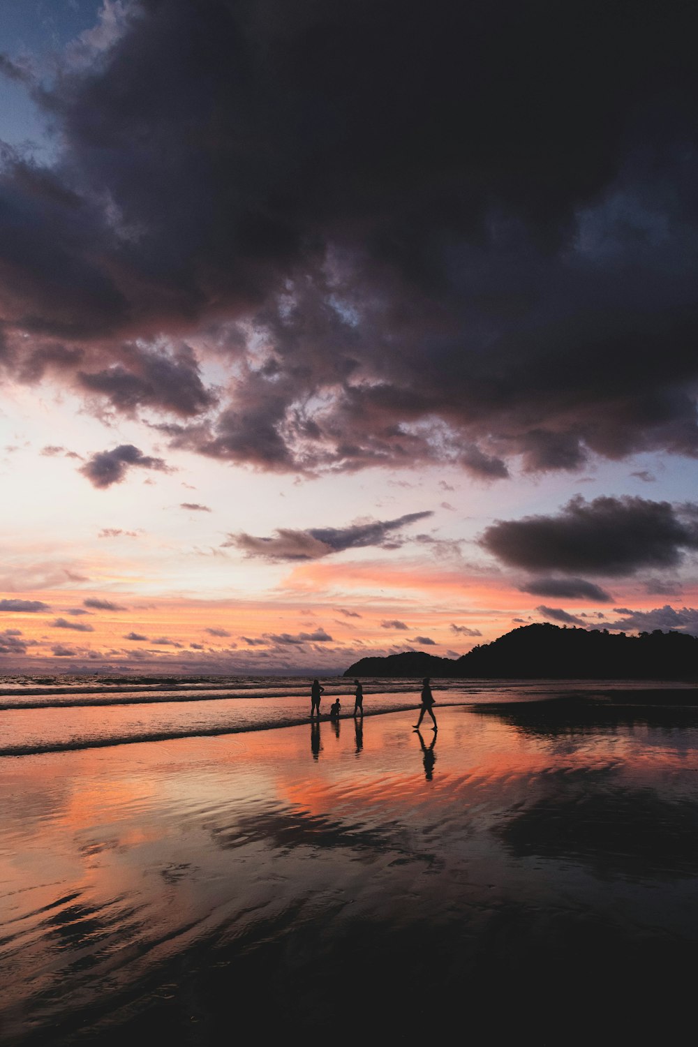 silhouette of people on beach during sunset