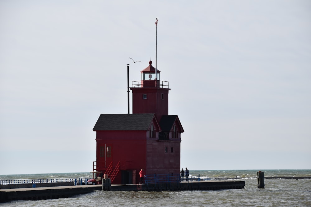 red and white wooden house near body of water during daytime