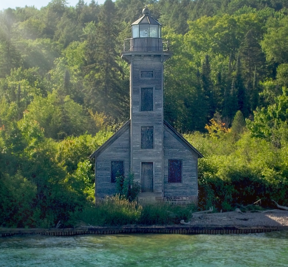 a small light house sitting on top of a lake