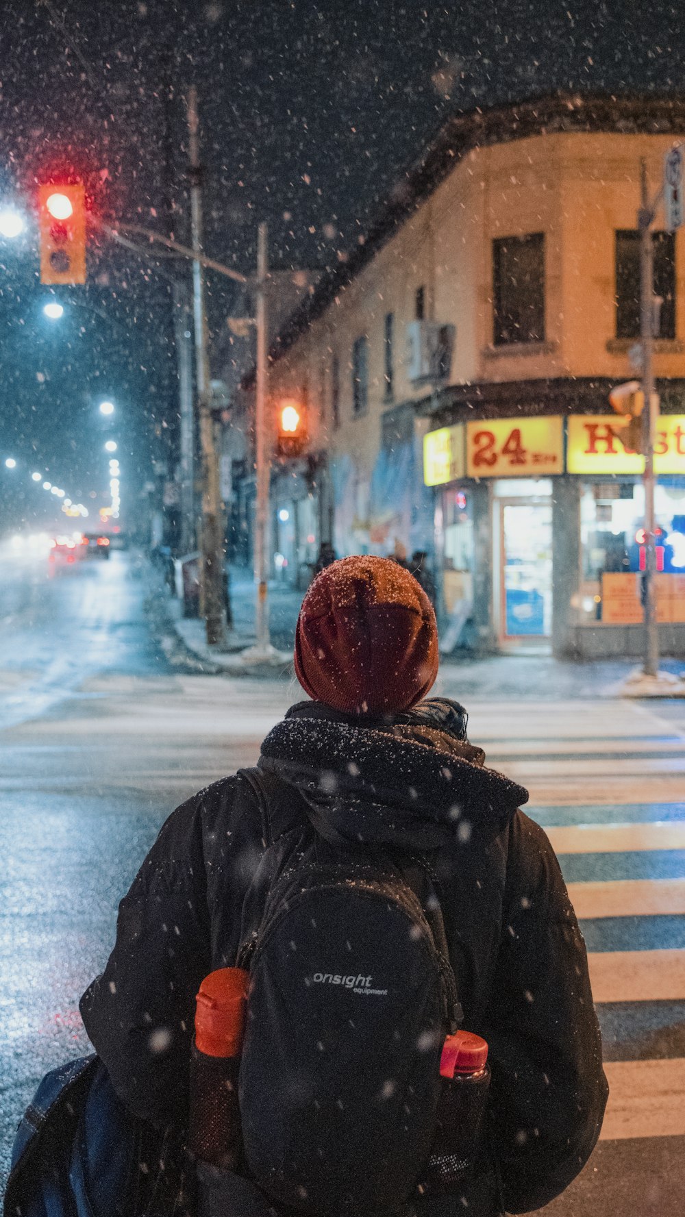 person in black jacket and brown knit cap standing on road during daytime