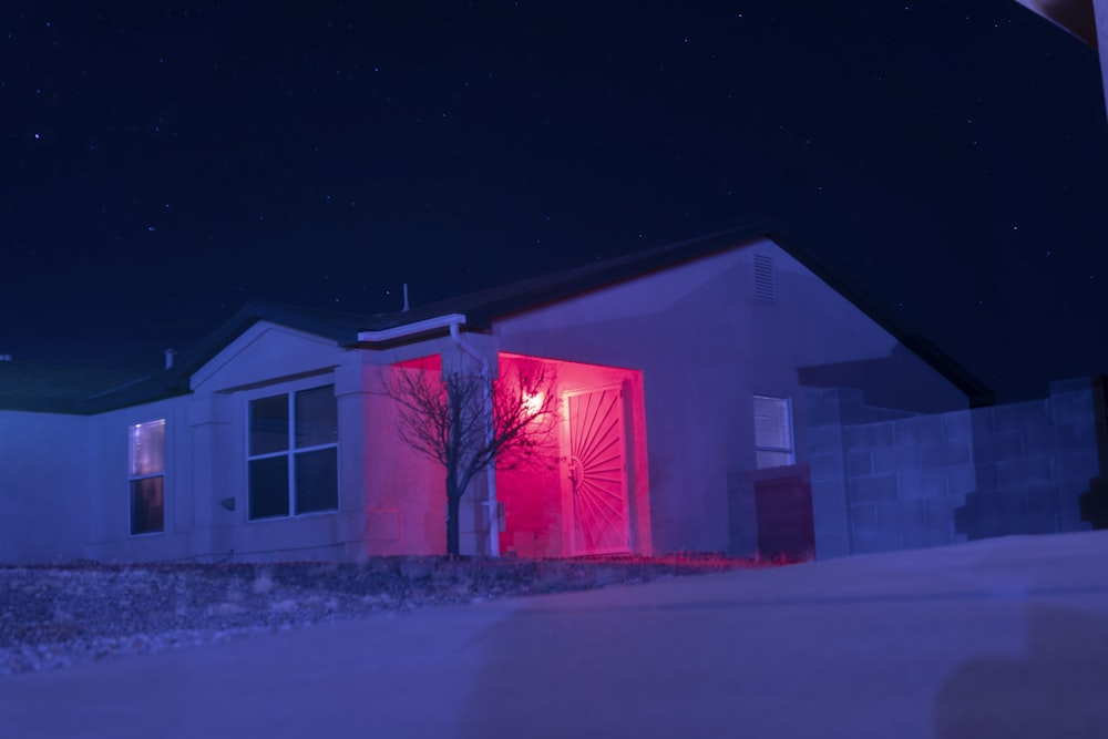 white and red house with lights turned on during night time