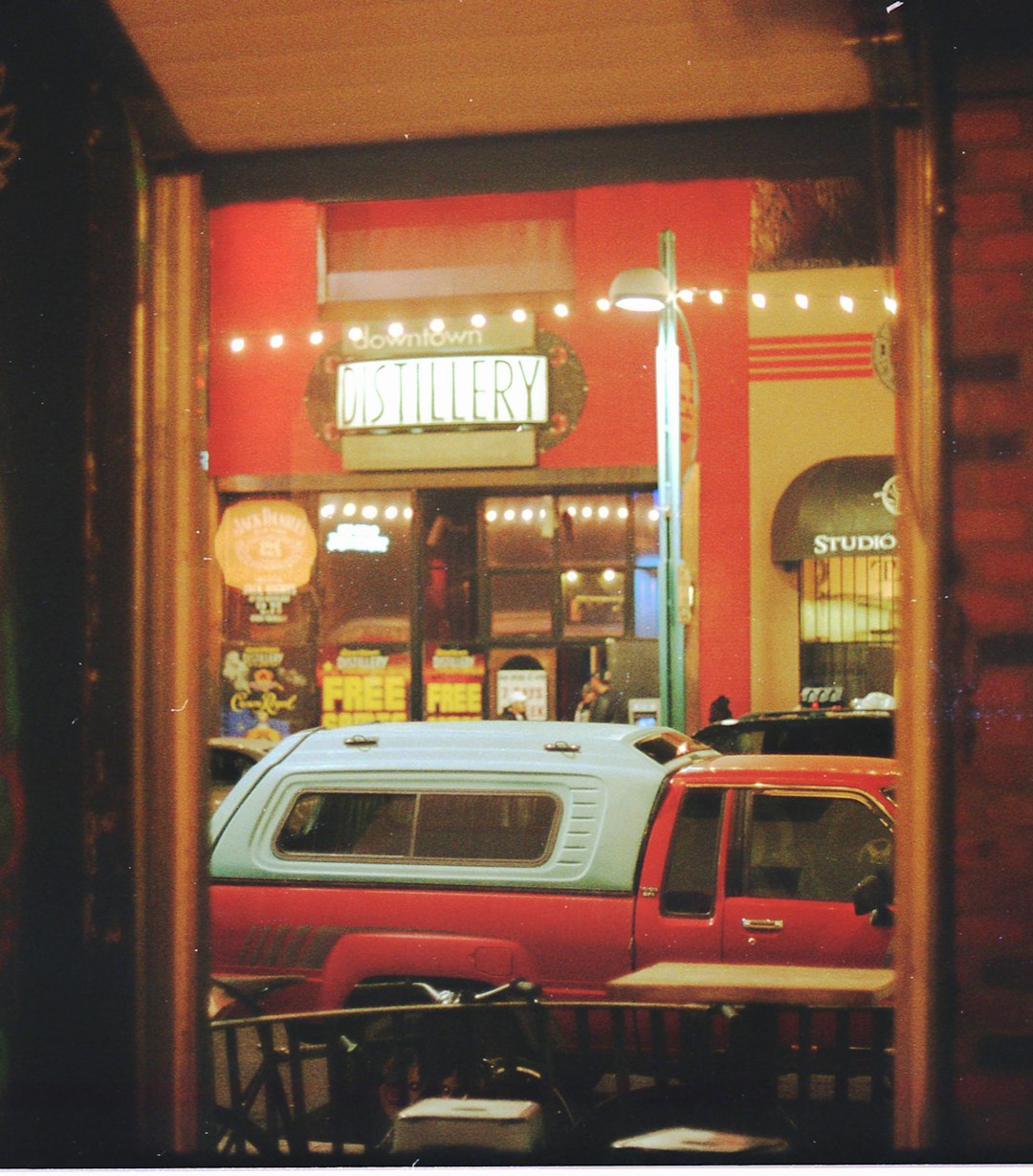 red and white cars parked beside store during night time