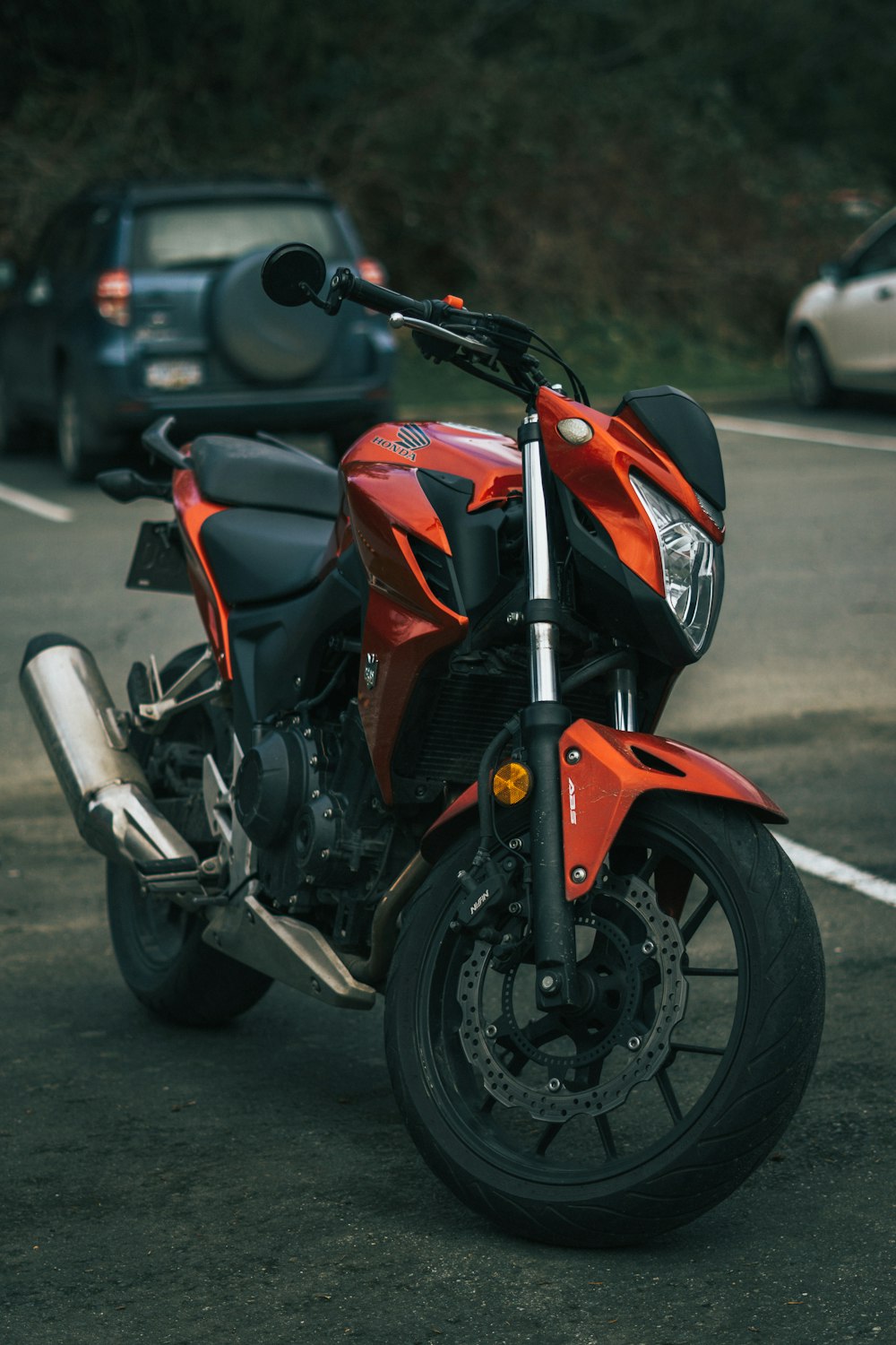 a red motorcycle parked on the side of the road