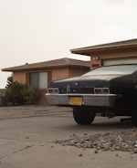 Car parked in front of a cozy house, representing home insurance.