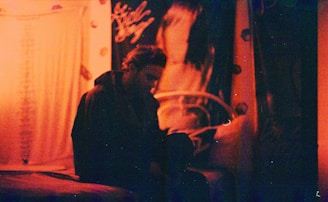 A cozy dark-themed room with a glowing neon orange anime poster on the wall.