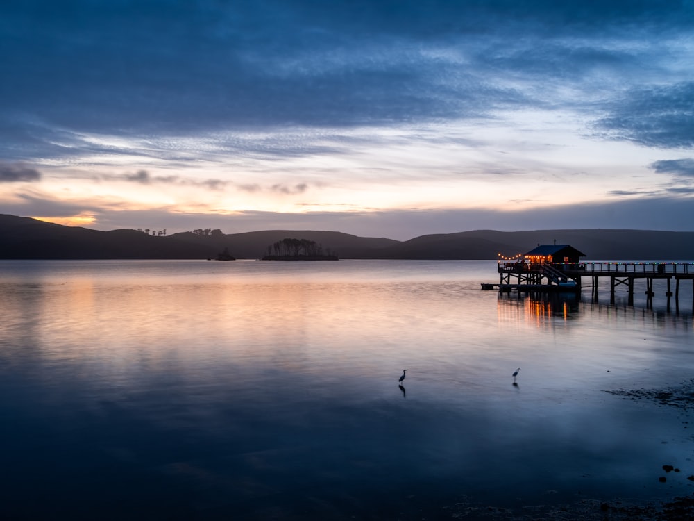 silhouette of a boat on water during sunset