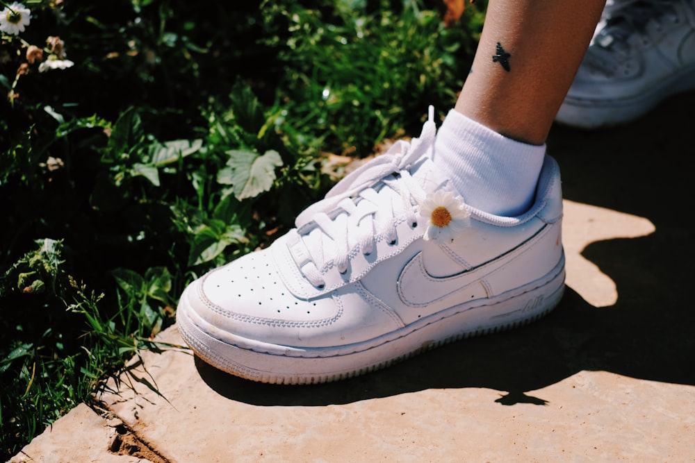 person wearing white nike air force 1 low