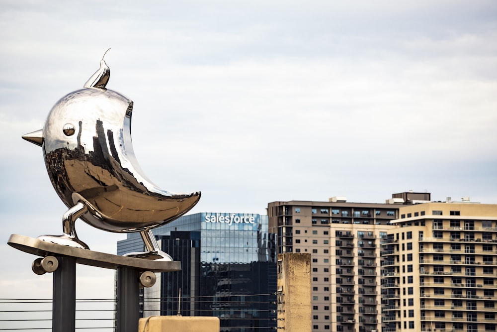 white and brown bird statue near city buildings during daytime