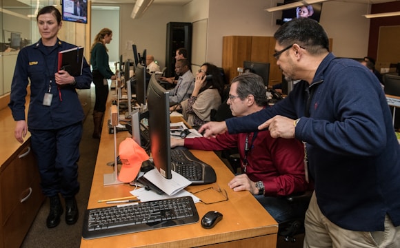 man in blue jacket using computer