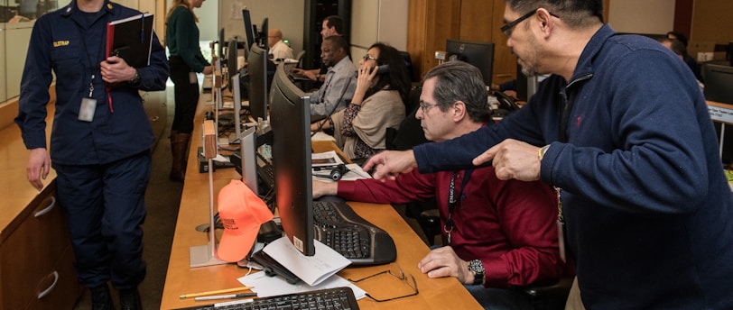 man in blue jacket using computer