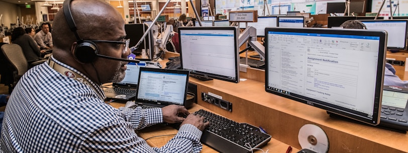 man in black and white checkered dress shirt using computer