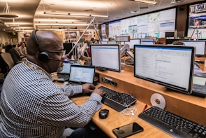 man in black and white checkered dress shirt using computer