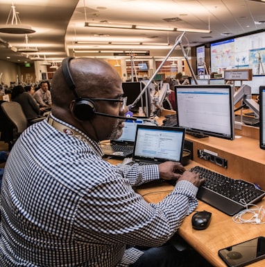 man in black and white checkered dress shirt using computer