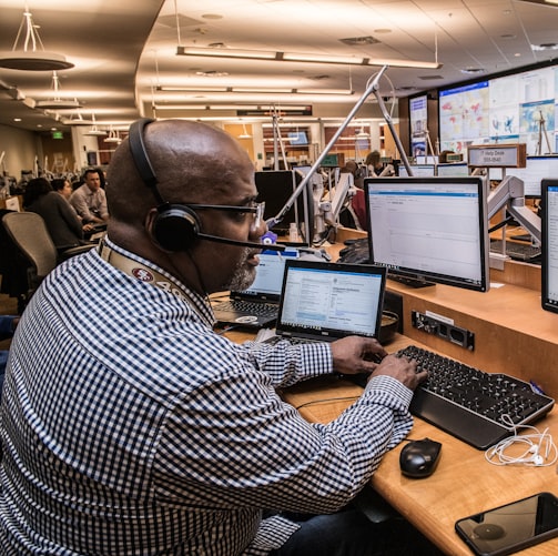 man in black and white checkered dress shirt using computer