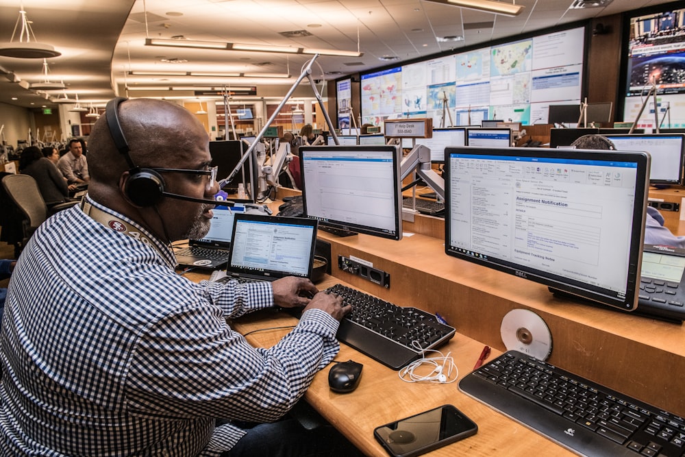 man in black and white checkered dress shirt using computer