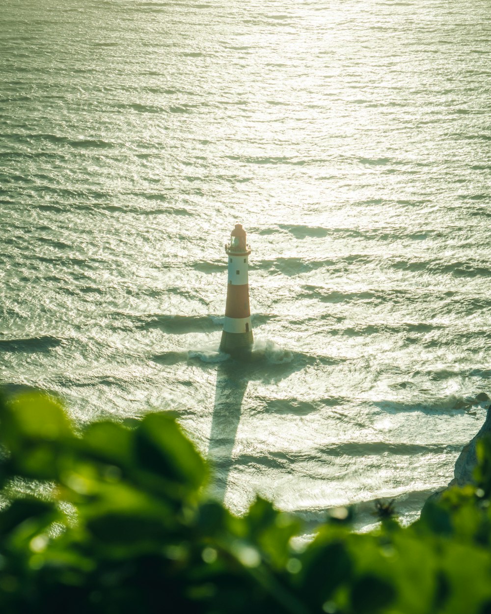 white and brown lighthouse near body of water during daytime