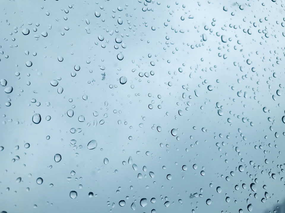 Close-up view of a window with scattered water droplets creating textured glass pattern