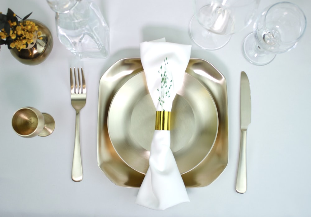 stainless steel fork and bread knife on white ceramic plate