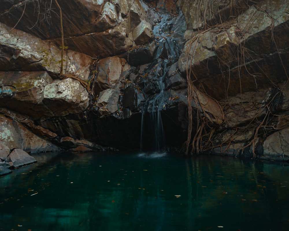 brown rocky mountain beside body of water during daytime