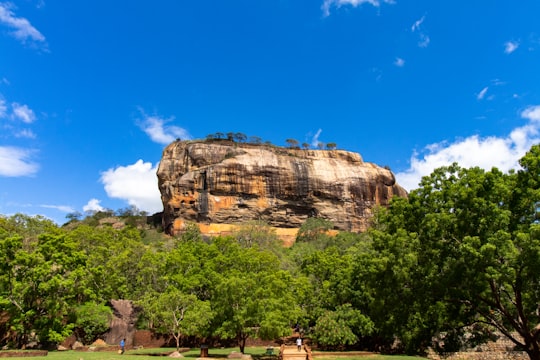 brown rock formation under blue sky during daytime in Ancient City of Sigiriya Sri Lanka