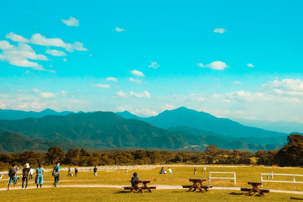people on brown field near mountains during daytime