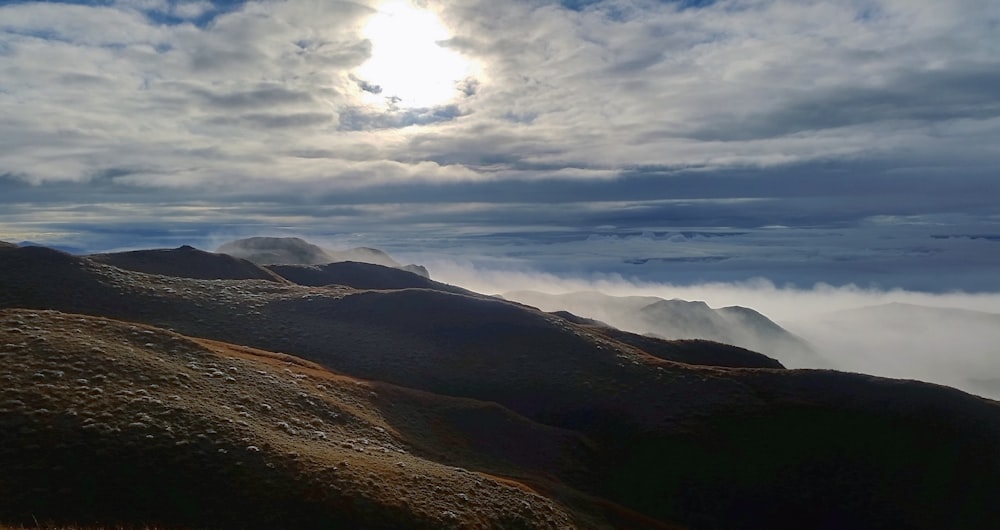 brown mountain under white clouds during daytime