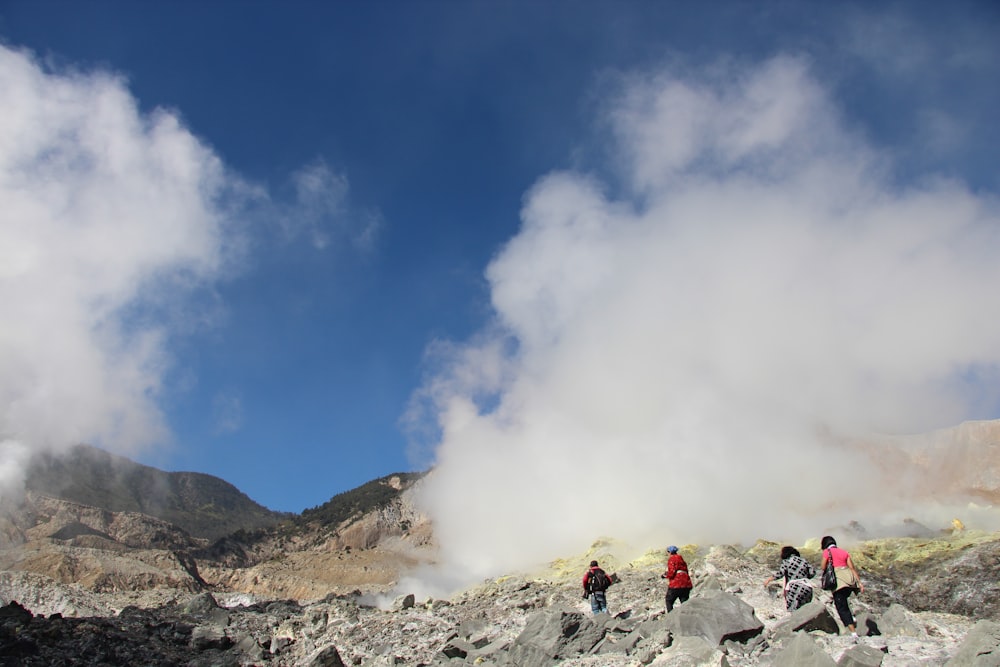 people on rocky mountain under blue sky during daytime